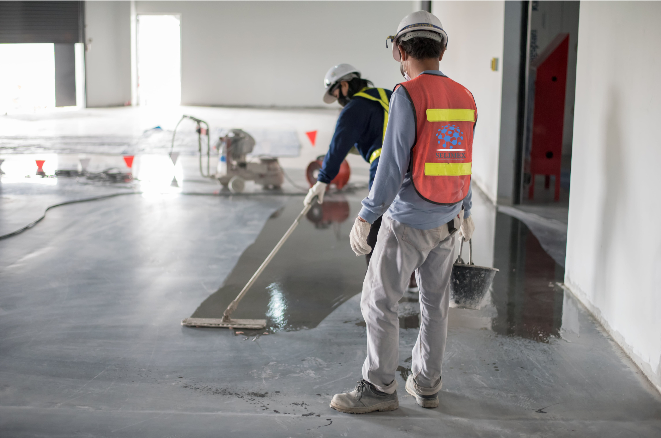 Staff in SELIMEX vests working in a space under construction