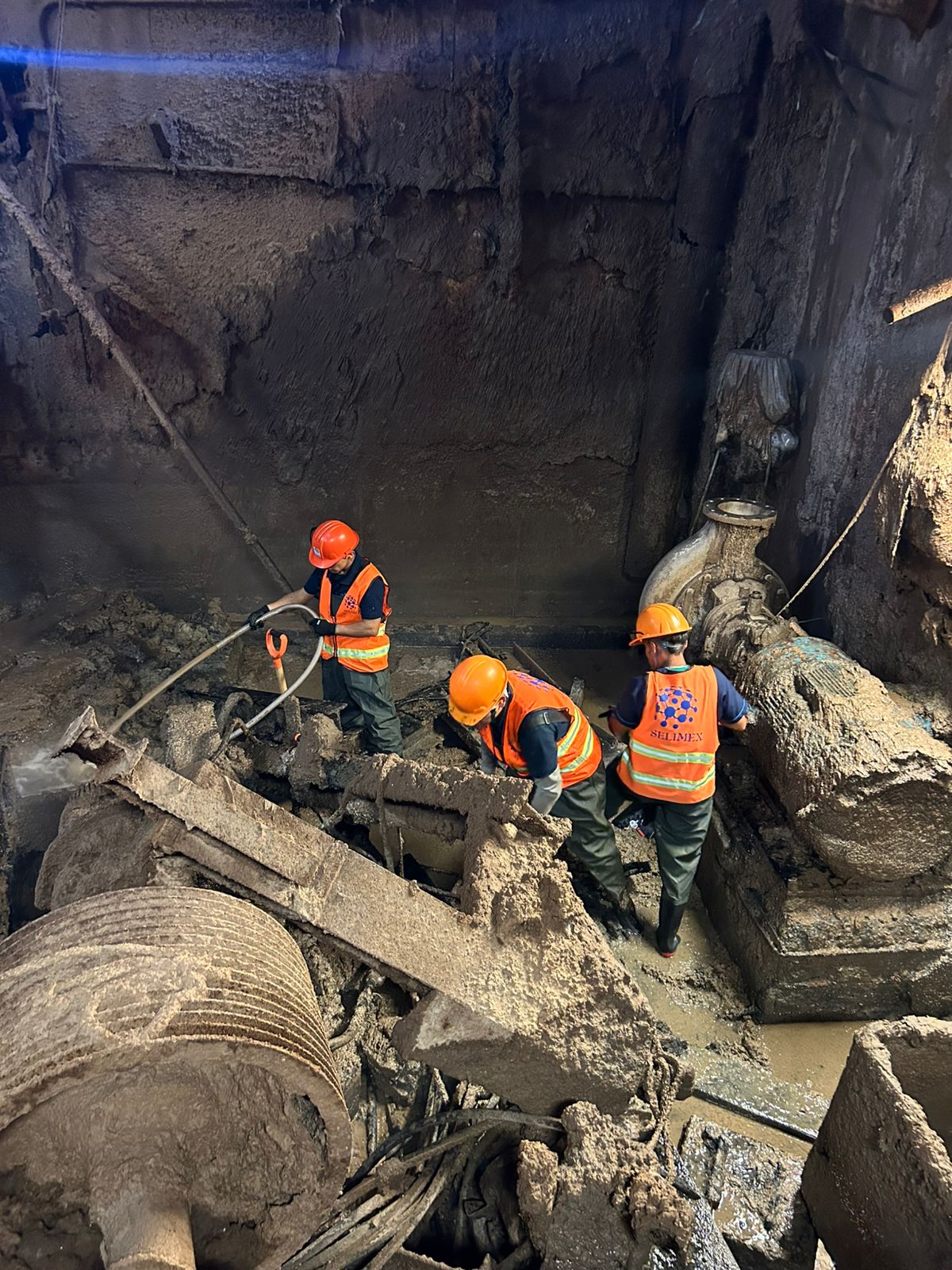 Staff in SELIMEX vests doing heavy-duty cleaning at a facility
